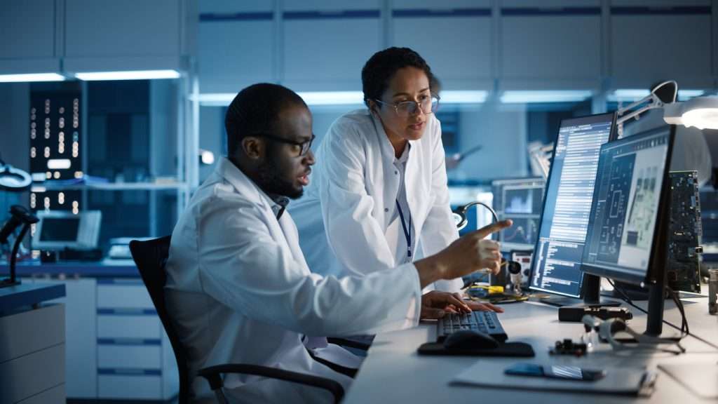 Engineers discussing solutions to semiconductor design challenges in a laboratory