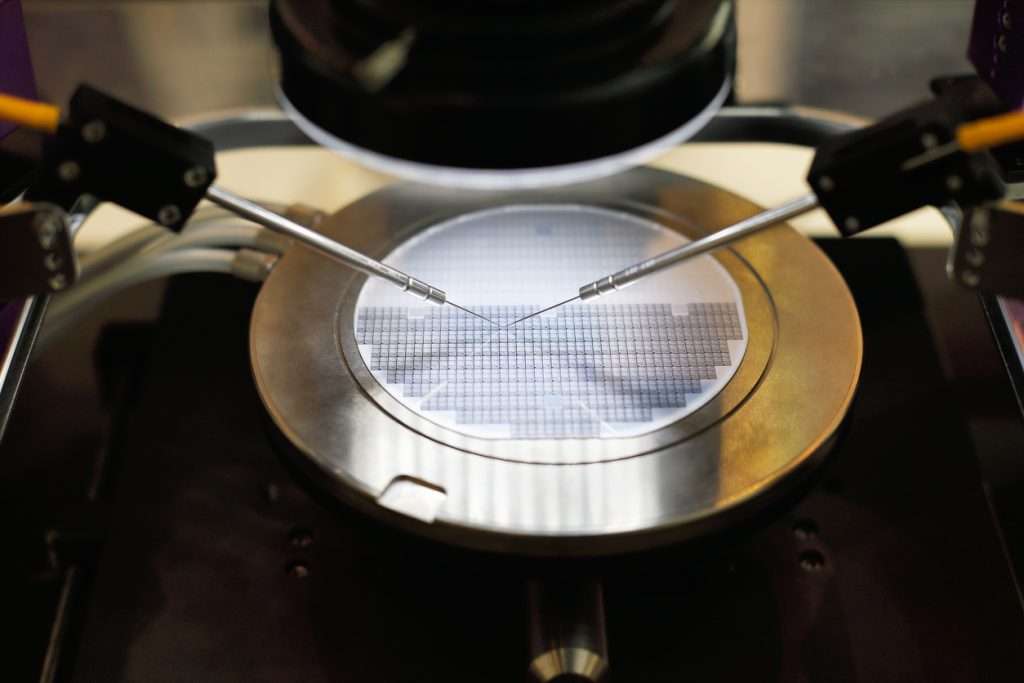 Semiconductor silicon wafer with advanced semiconductor materials undergoing probe testing