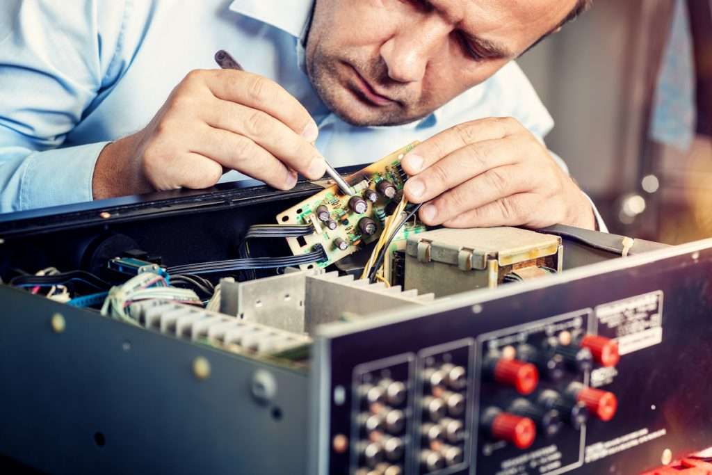 Electrical expert repairing audio amplifier equipment